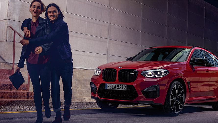 Čovek i žena se smeju ispred BMW-a BMW finansijske usluge BMW lizing čovek i žena se smeju ispred BMW-a