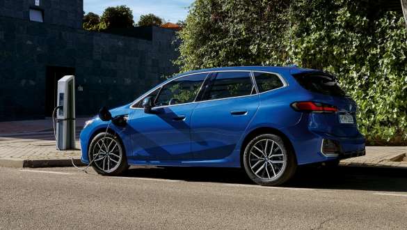 BMW Serija 2 Active Tourer 230e plug-in hibrid U06 2021 M Portimao plave metalik boje bočni prikaz parkiranog vozila na stanici za punjenje električnom energijom