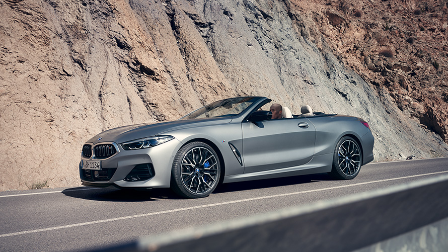 BMW Serije 8 Kabriolet G14 LCI Facelift 2022 BMW Individual Frozen Pure sive metalik boje bočni prikaz vozila sa otvorenim mekanim krovom tokom brdske vožnje