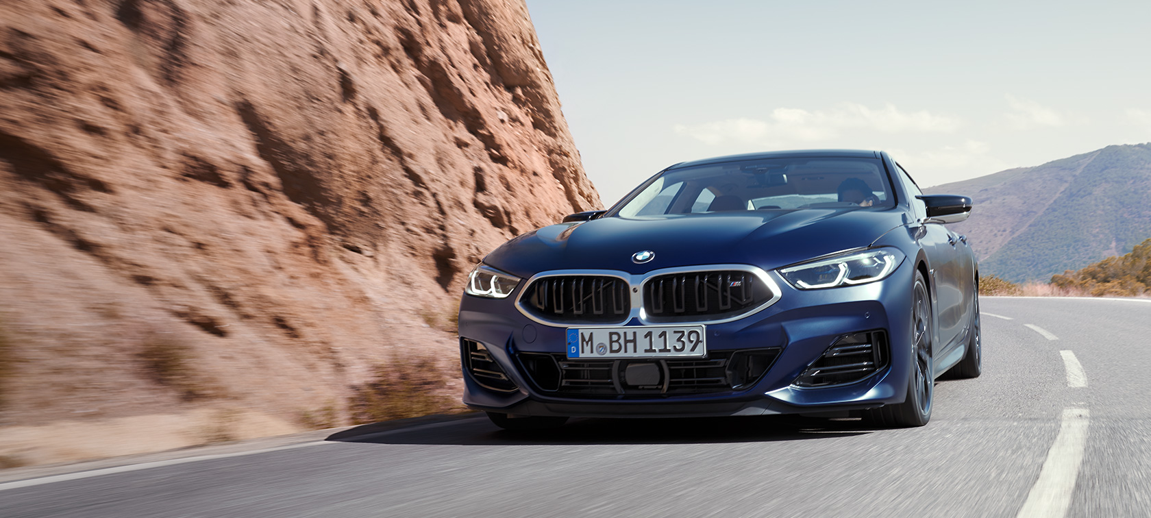 BMW Serije 8 Gran Coupé G16 LCI Facelift 2022 BMW Individual Frozen Tanzanite plave metalik boje tročetvrtinski prednji prikaz vozila prilikom vožnje planinskim putem