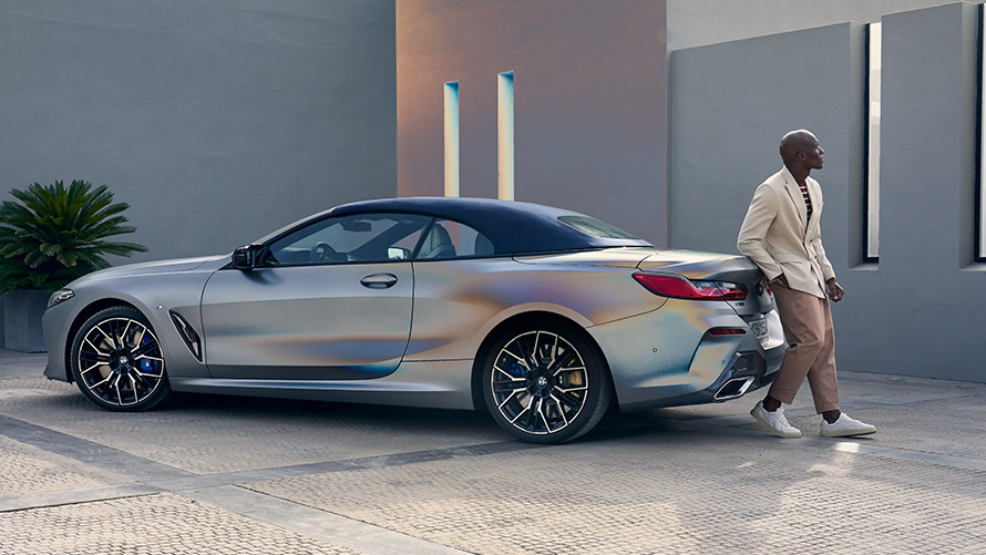 BMW M850i xDrive Kabriolet G14 LCI Facelift 2022 BMW Individual Frozen Pure siva metalik boja tročetvrtinski zadnji prikaz s modelom naslonjenim na vozilu