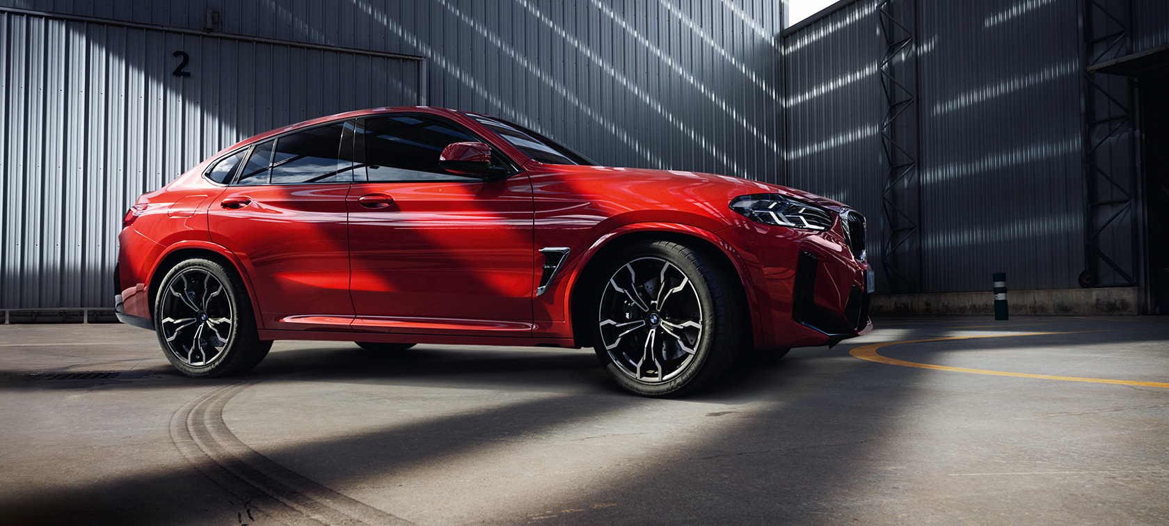 BMW X4 M Competition F98 LCI Facelift 2021 Toronto crvene metalik boje tročetvrtinski prednji prikaz u zgradi fabrike