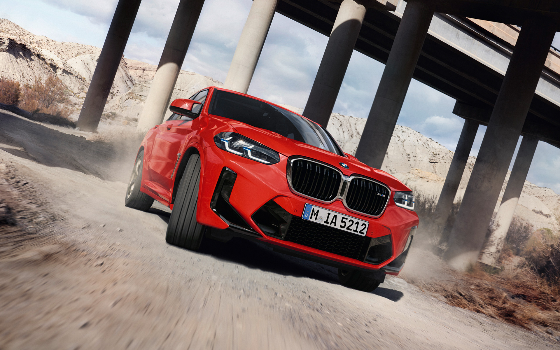 BMW X4 M F98 LCI Facelift 2021 Toronto crvene metalik boje tročetvrtinski prednji prikaz ispod stubova mosta