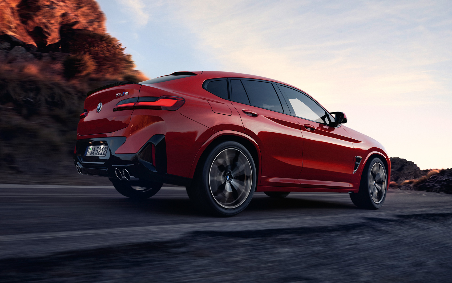 BMW X4 M F98 LCI Facelift 2021 Toronto crvene metalik boje tročetvrtinski stražnji prikaz vozila na putu