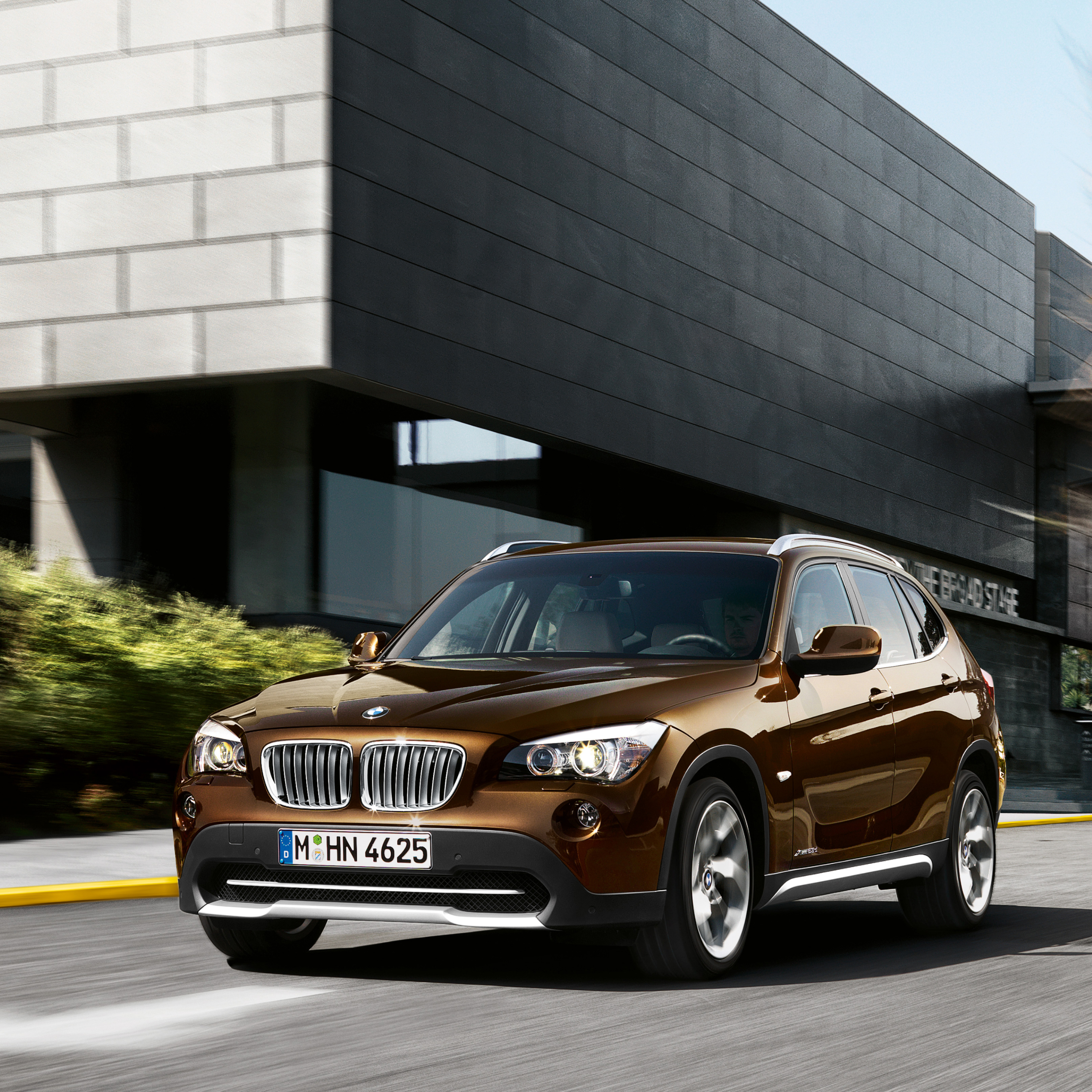 BMW X1 E84 SUV vožnja centralnom ulicom modernog grada