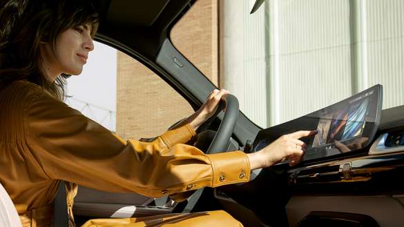 BMW X1 Series woman controlling the touch UI of the car