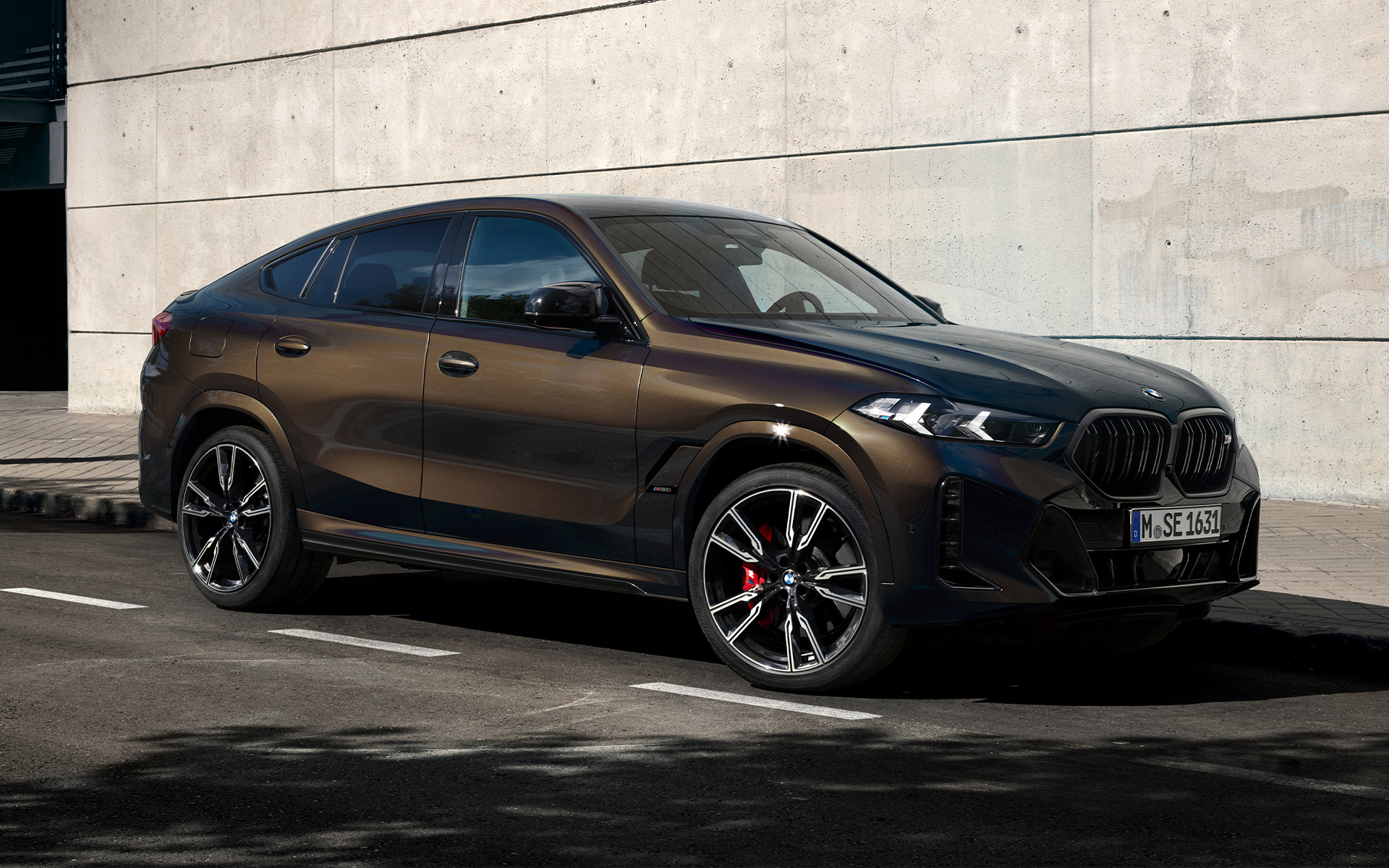 BMW X6 M60i G06 u BMW Individual Pyrite Brown metalik, 2/3 bočni prikaz na parkingu