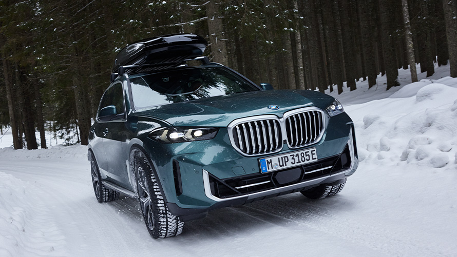 BMW Winter kompletni točkovi na BMW-u X5 (G05 LCI) na snegom prekrivenom putu u šumi