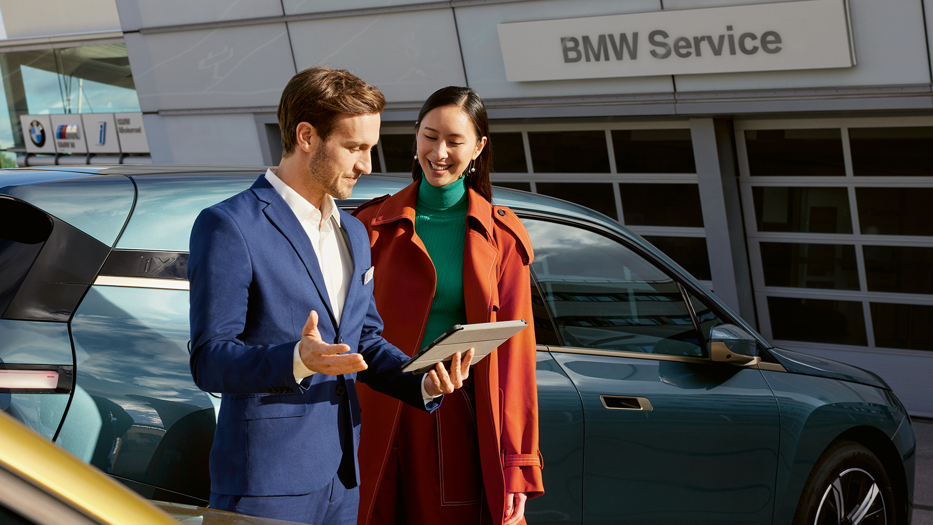 BMW Value Service čovek i žena ispred garaže sa BMW X5